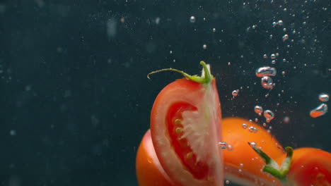 Scheiben-Reifer-Tomaten-Unter-Wasser-Mit-Luftblasen-Und-In-Zeitlupe.-Frisches-Und-Saftiges-Gesundes-Vegetarisches-Produkt.-Salatzutaten